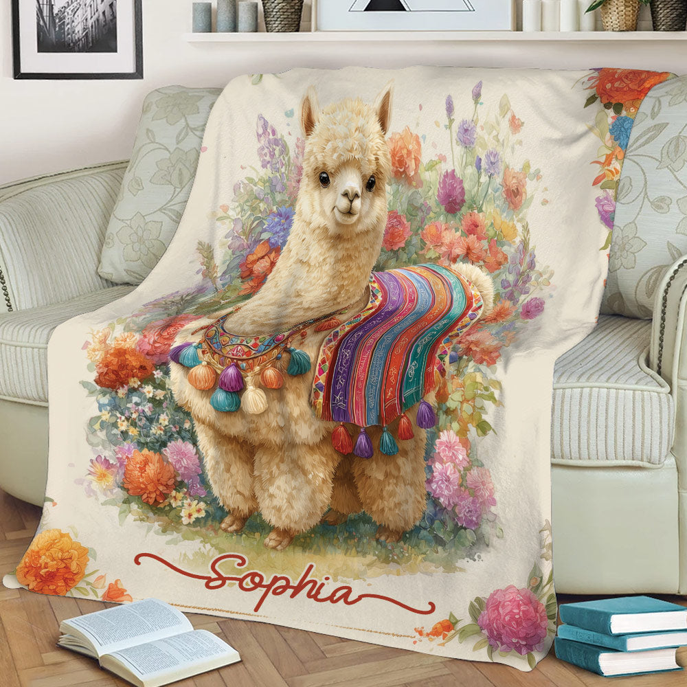 Colorful llama throw blanket draped over a sofa with flowers and decorative textile details