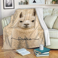 Cream llama throw blanket draped over a sofa with books and a mug for a cozy setting