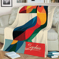 Vibrant geometric toucan blanket displayed on a sofa with colorful bird artwork