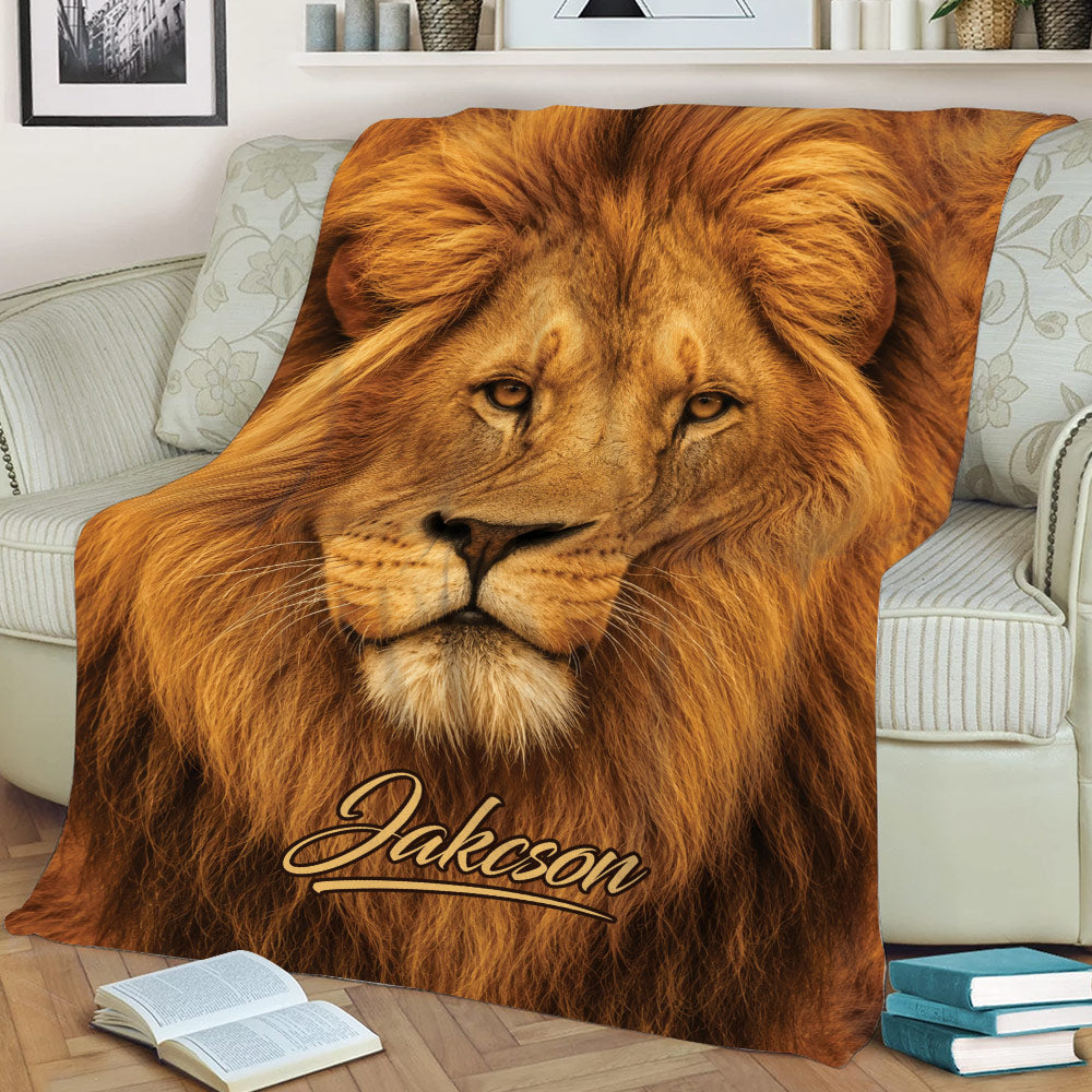 Close view of a lion throw blanket spread across a sofa with realistic golden mane artwork