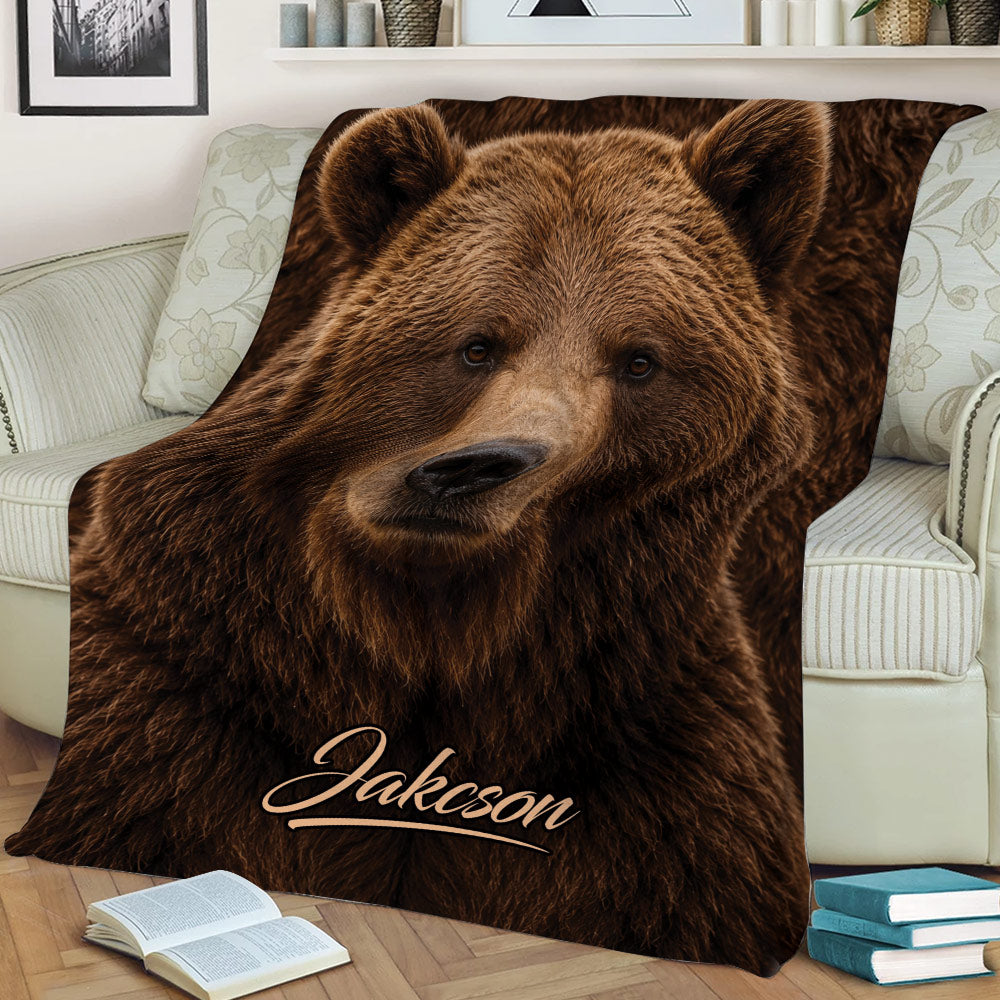 Close-up brown bear throw blanket styled on a sofa with books and home decor