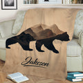 Mountain bear blanket displayed on a sofa with bold wildlife silhouettes and warm neutral colors