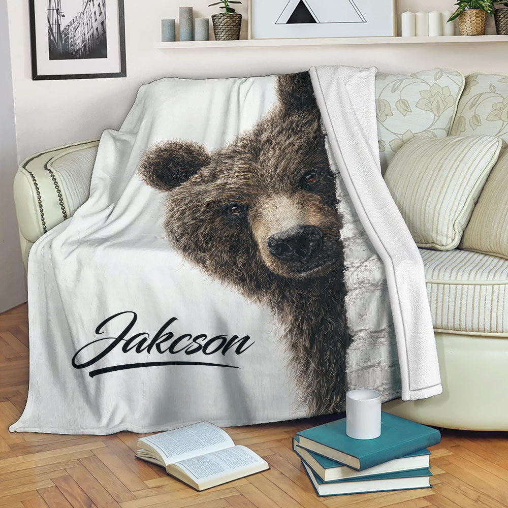 Bear throw blanket draped over a sofa with realistic woodland artwork in a cozy living room
