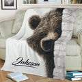 Woodland bear throw blanket styled on a sofa with a close-up bear and birch tree design