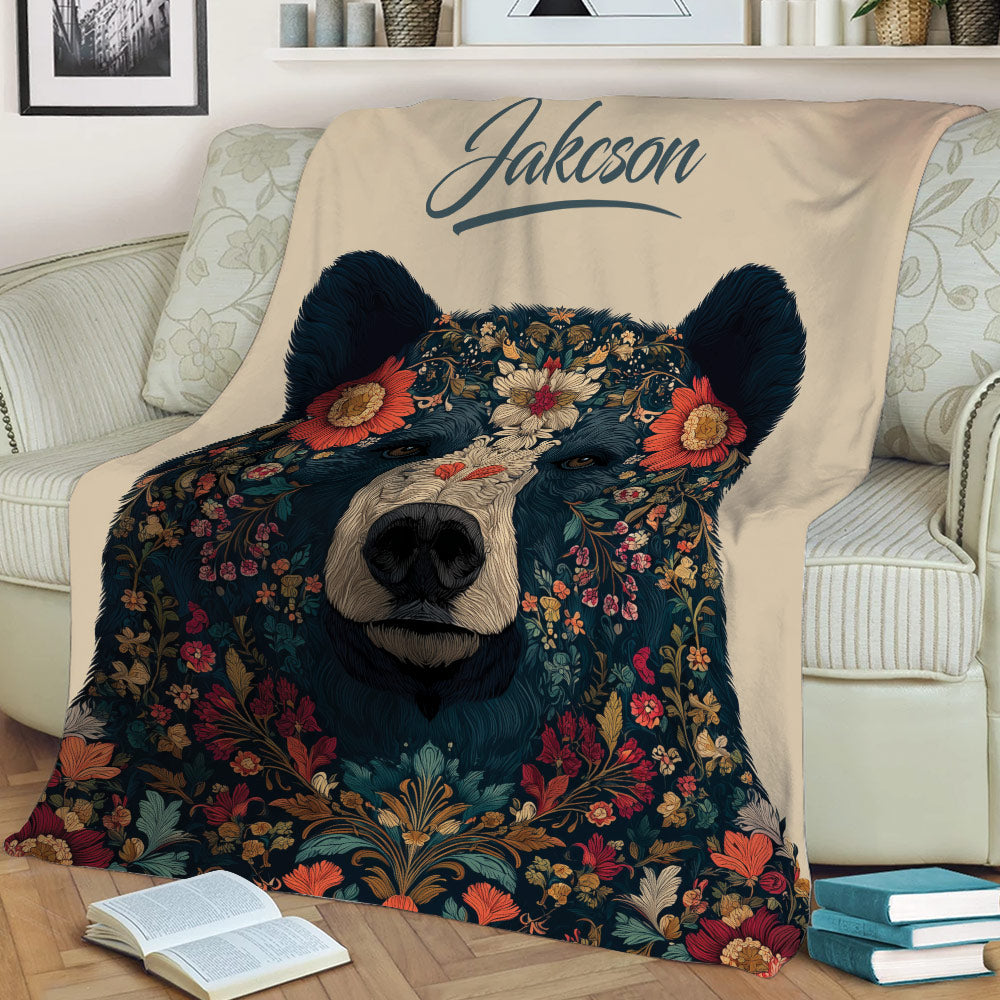 Close view of a decorative bear blanket with colorful flowers draped across a living room sofa