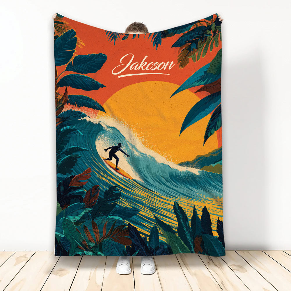 Surfing throw blanket featuring a silhouetted surfer riding a large tropical wave with bold sunset colors