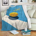 Custom blue pickleball blanket draped over a sofa with yellow ball artwork and a cozy living room setting