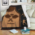 Pickleball blanket draped over a sofa with paddle artwork, player silhouettes, and a cozy living room setting