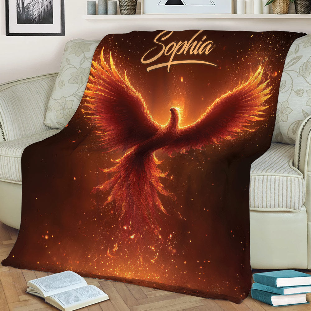 Bold phoenix throw blanket displayed on a sofa with glowing feathers and ember details