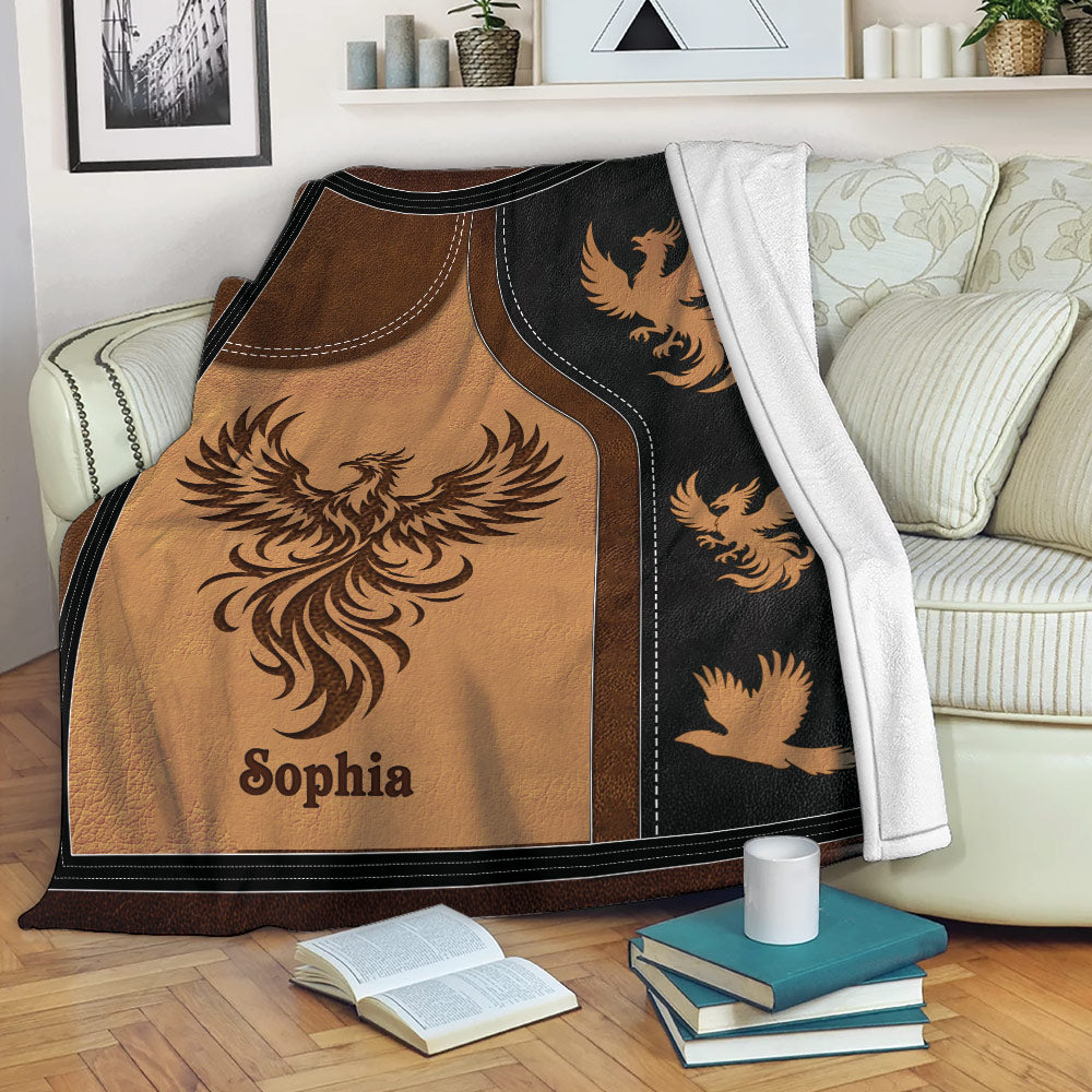 Phoenix blanket draped over a sofa with bold copper, brown, and black artwork
