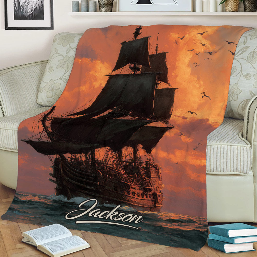 Pirate ship throw blanket draped over a sofa with seabirds, ocean waves, and warm sunset colors