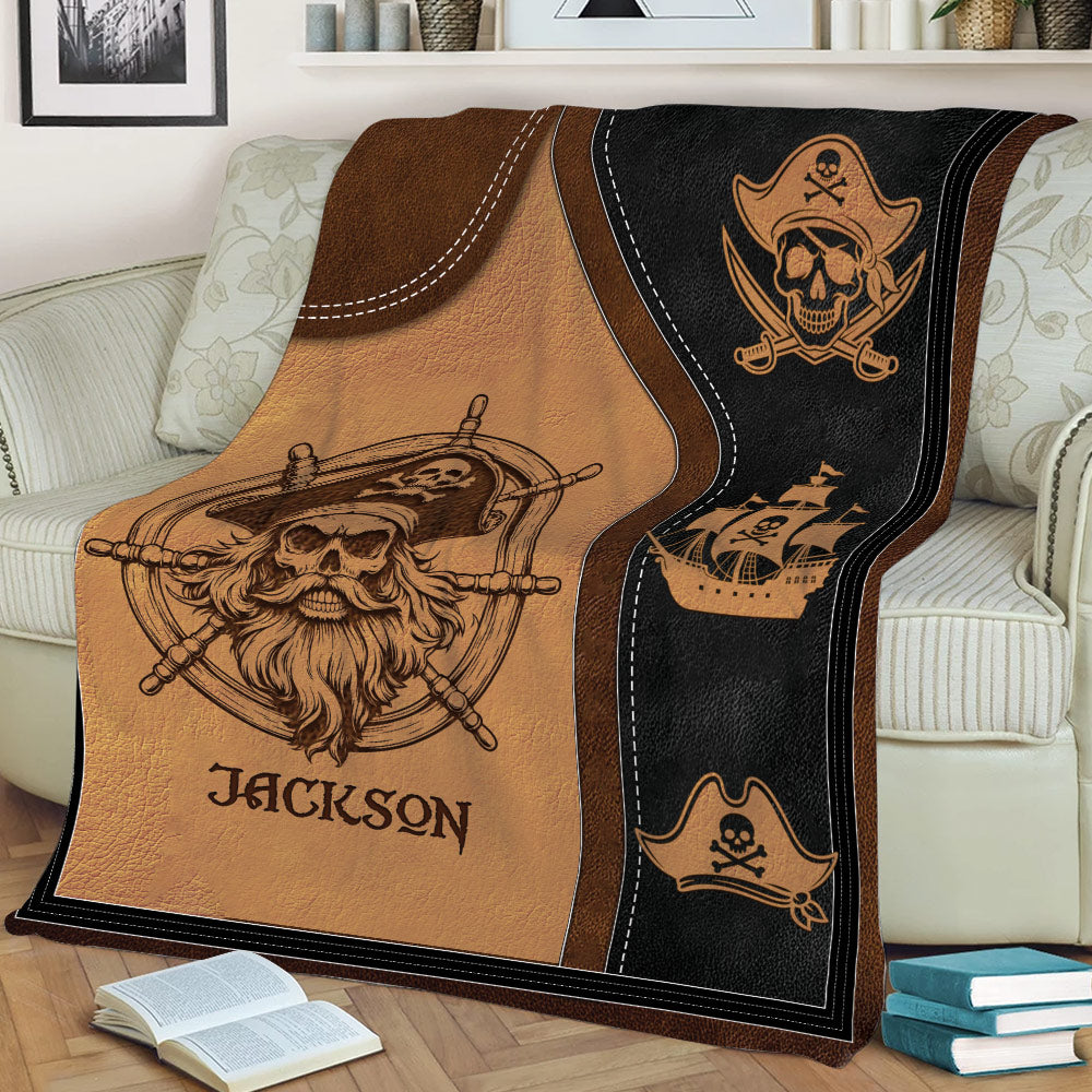 Close view of pirate blanket draped over a couch with skull captain and ship artwork in brown and black
