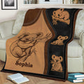 Close view of a koala blanket draped over a sofa with illustrated koalas and earthy tones