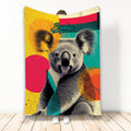 Colorful koala throw blanket with bold geometric shapes displayed in a full-length lifestyle setting