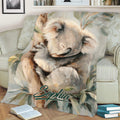 Close lifestyle view of a koala blanket with gentle wildlife artwork on a comfortable sofa
