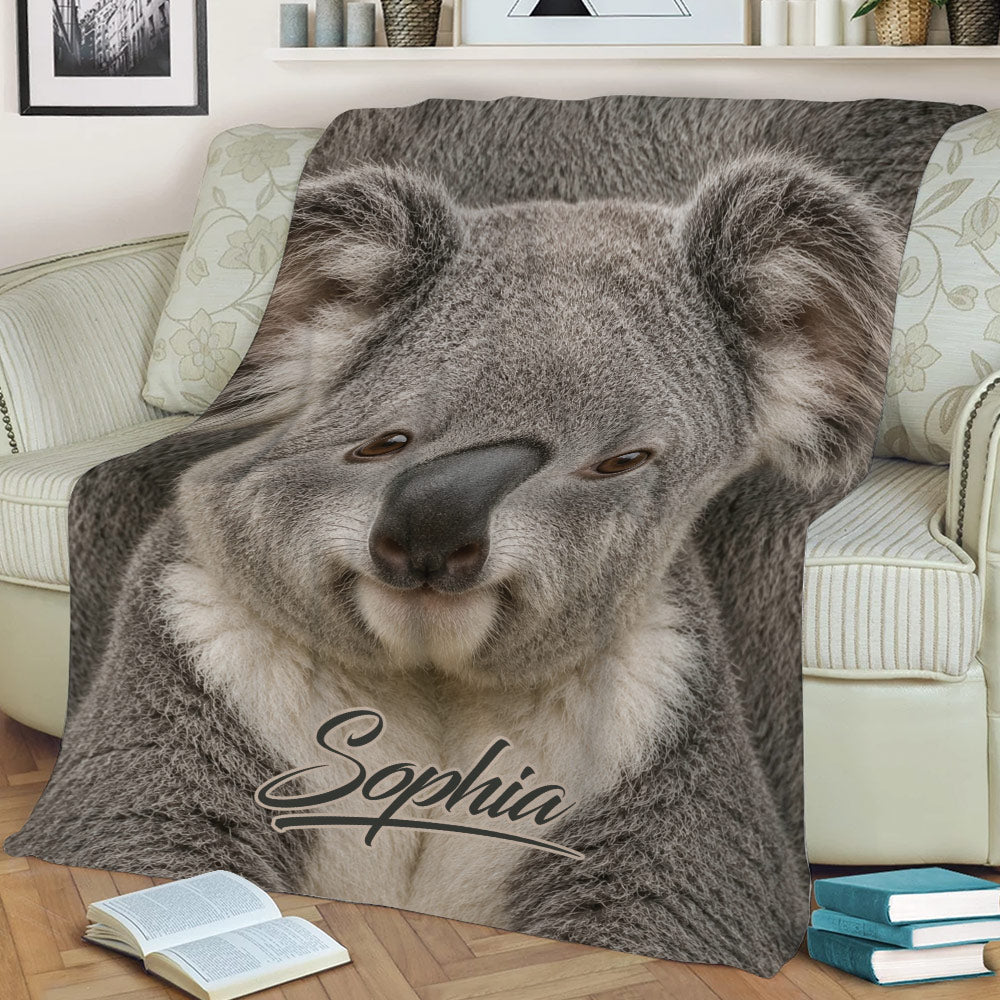 Close-up koala blanket spread across a sofa with a detailed wildlife design