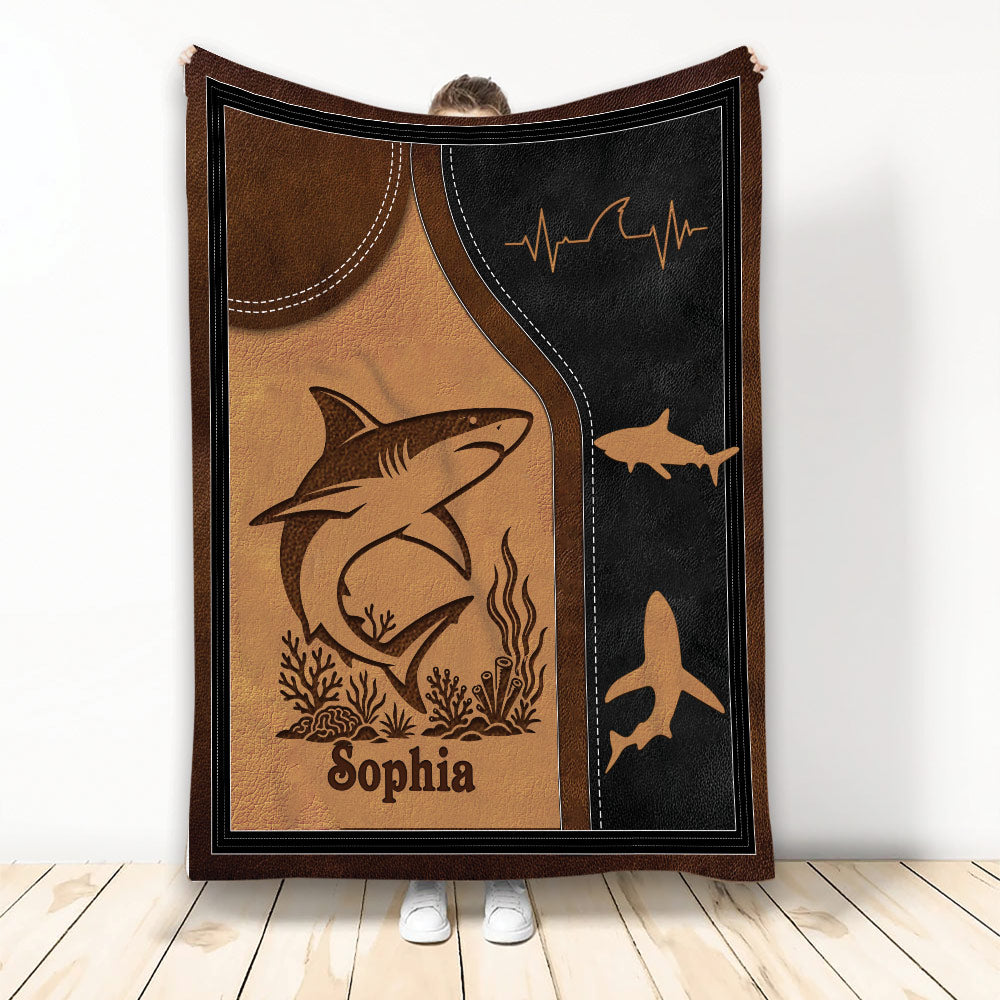 Shark throw blanket featuring an illustrated shark, underwater plants, and coastal brown and black artwork