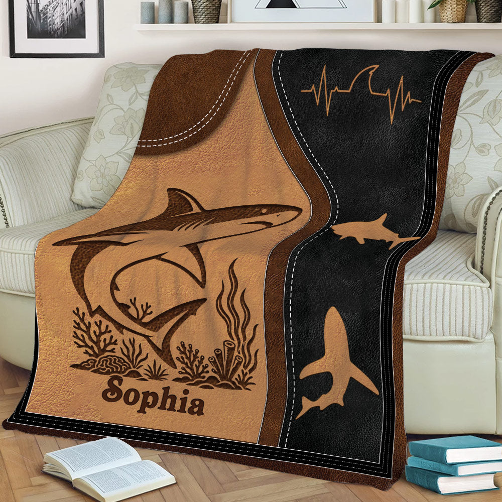 Close view of a shark blanket with illustrated marine life, stitched-style borders, and bold ocean artwork