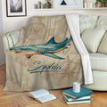 Shark blanket draped over a sofa with vintage nautical map and compass artwork