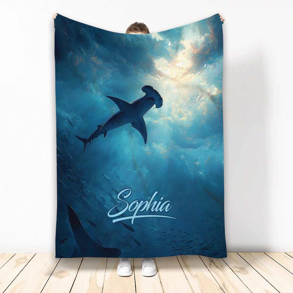 Shark throw blanket displayed against an underwater scene with a hammerhead shark and deep blue ocean artwork