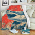 Shark blanket draped over a sofa with bold ocean artwork and red, cream, and navy colors