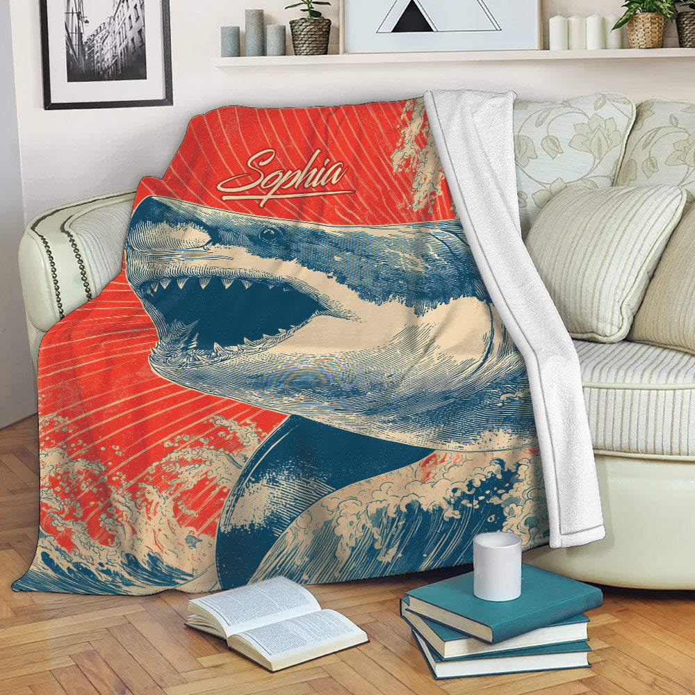 Shark blanket draped over a sofa with bold ocean artwork and red, cream, and navy colors