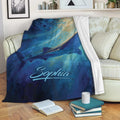 Whale shark blanket draped over a sofa, showing colorful underwater artwork in deep blue tones