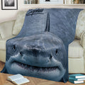 Close view of a realistic shark blanket styled over a sofa with ocean-inspired artwork