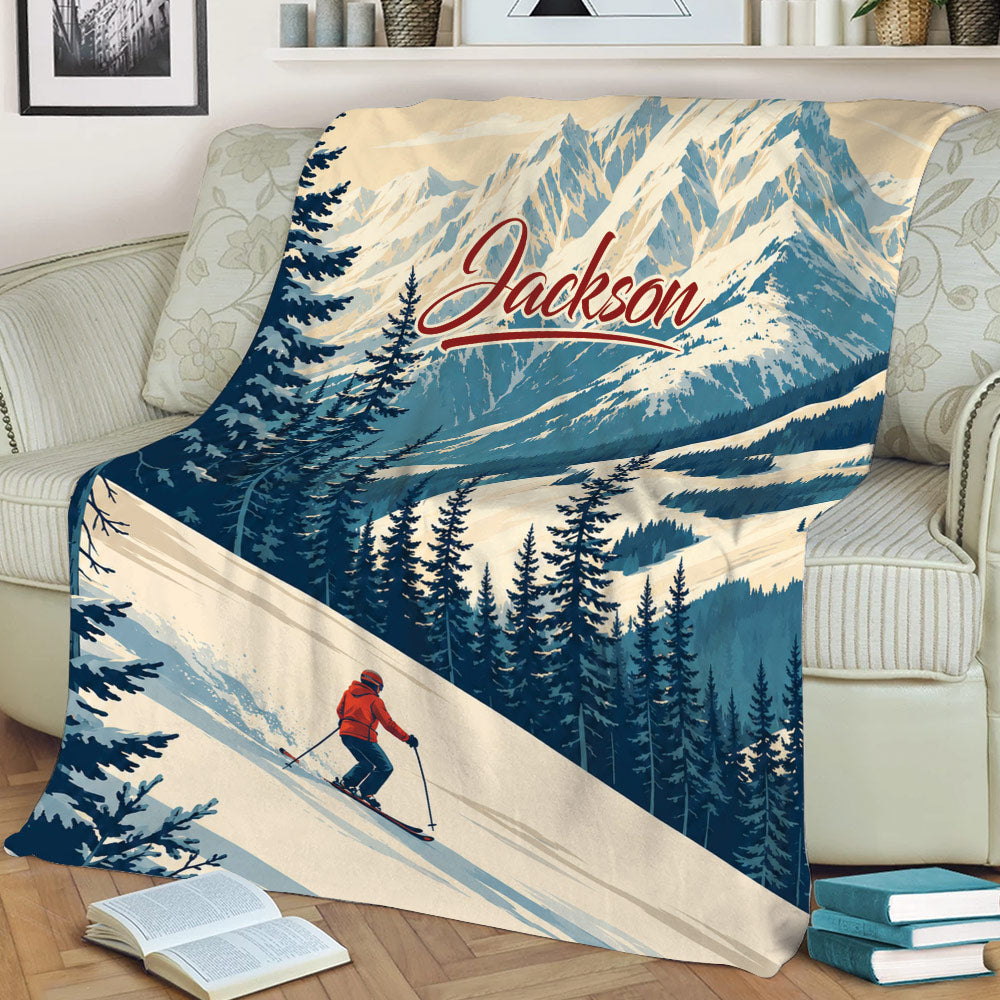 Mountain skiing blanket displayed on a sofa with snowy peaks, pine trees, and skier artwork