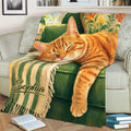 Close view of sleeping orange tabby cat artwork on a cozy living room throw blanket