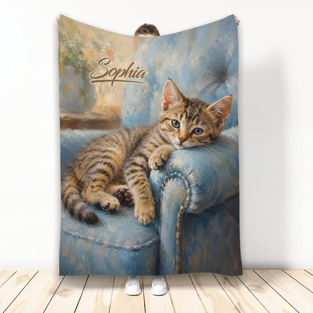 Tabby cat throw blanket featuring a cozy kitten resting on a blue painted armchair
