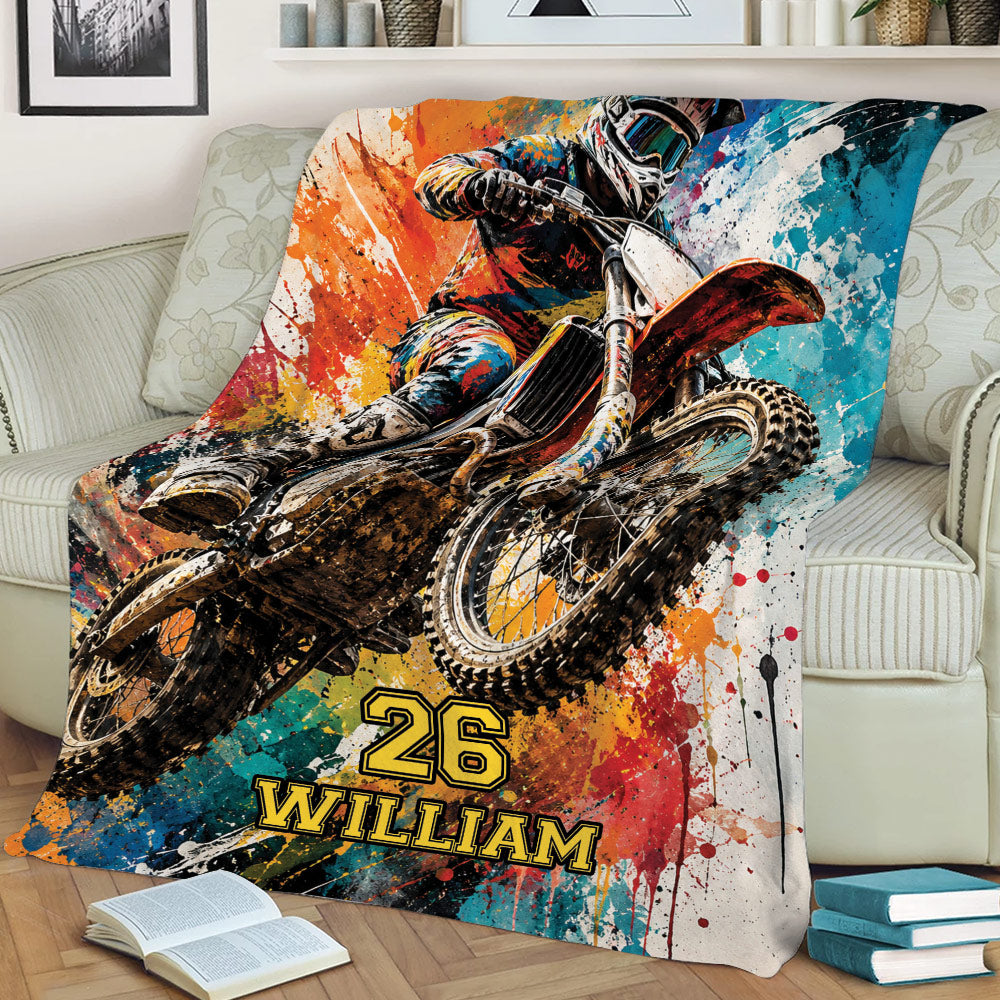 Motocross throw blanket draped over a sofa with dynamic dirt bike rider artwork