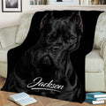 Close view of a black Cane Corso throw blanket styled across a sofa with a dramatic dog portrait