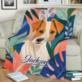 Close view of a Jack Russell Terrier throw blanket with vibrant abstract leaf artwork on a sofa