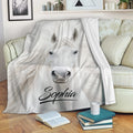 White horse throw blanket draped over a sofa in a cozy living room setting