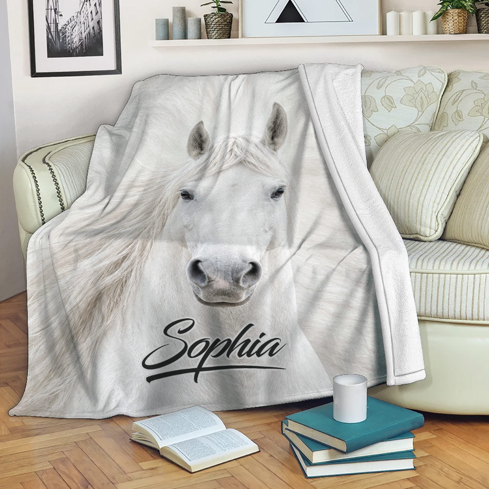 White horse throw blanket draped over a sofa in a cozy living room setting