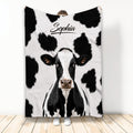 Black and white cow throw blanket displayed with a large cow face and spotted farm animal design