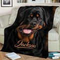 Close view of a black and tan Rottweiler throw blanket styled across a living room sofa