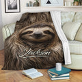 Sloth throw blanket draped over a sofa with cozy living room decor and sloth artwork