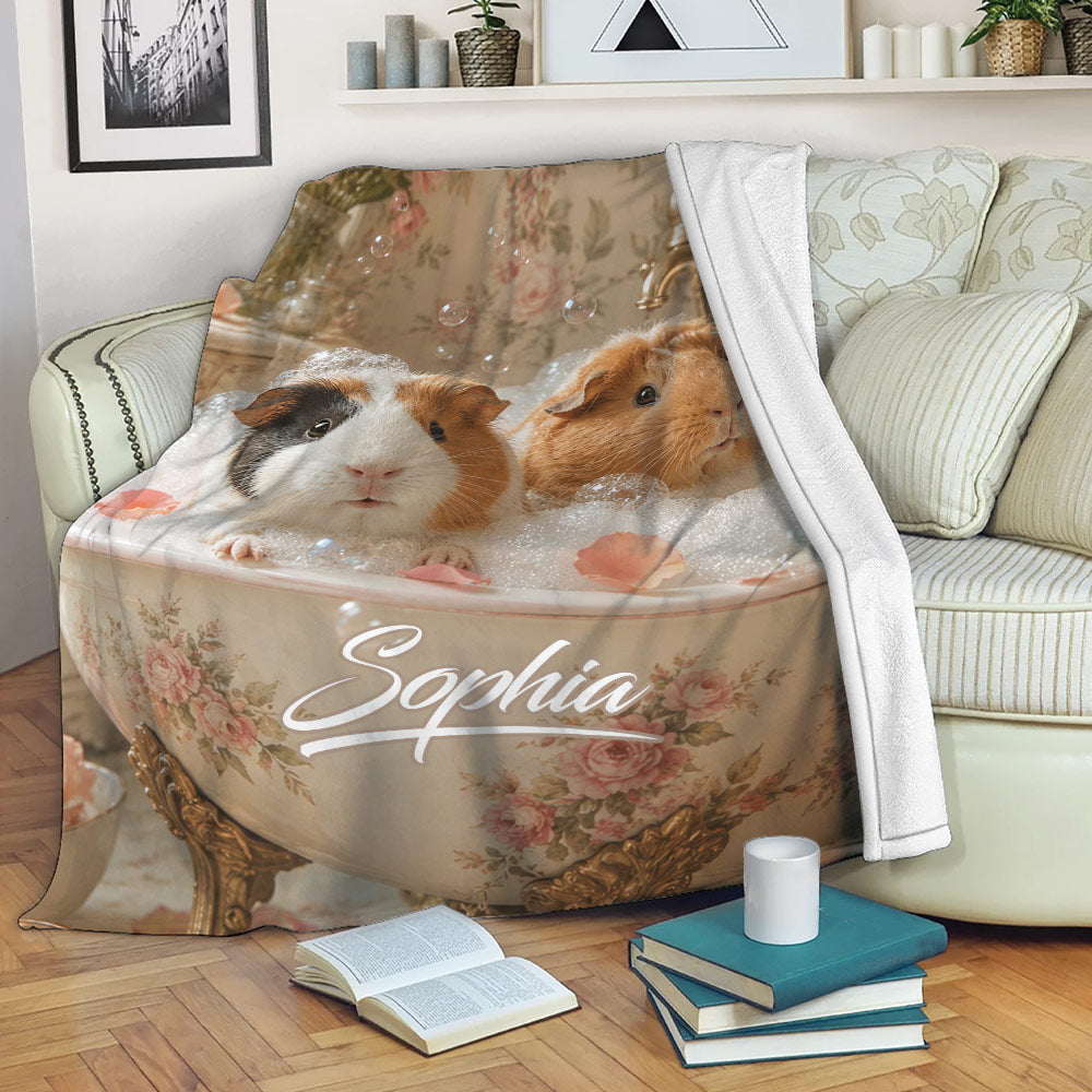 Guinea pig throw blanket displayed on a sofa with whimsical bath artwork and floral details