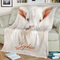 Close-up white goat throw blanket styled across a sofa with books nearby