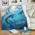 Dolphin throw blanket draped over a sofa with vivid underwater artwork and ocean colors