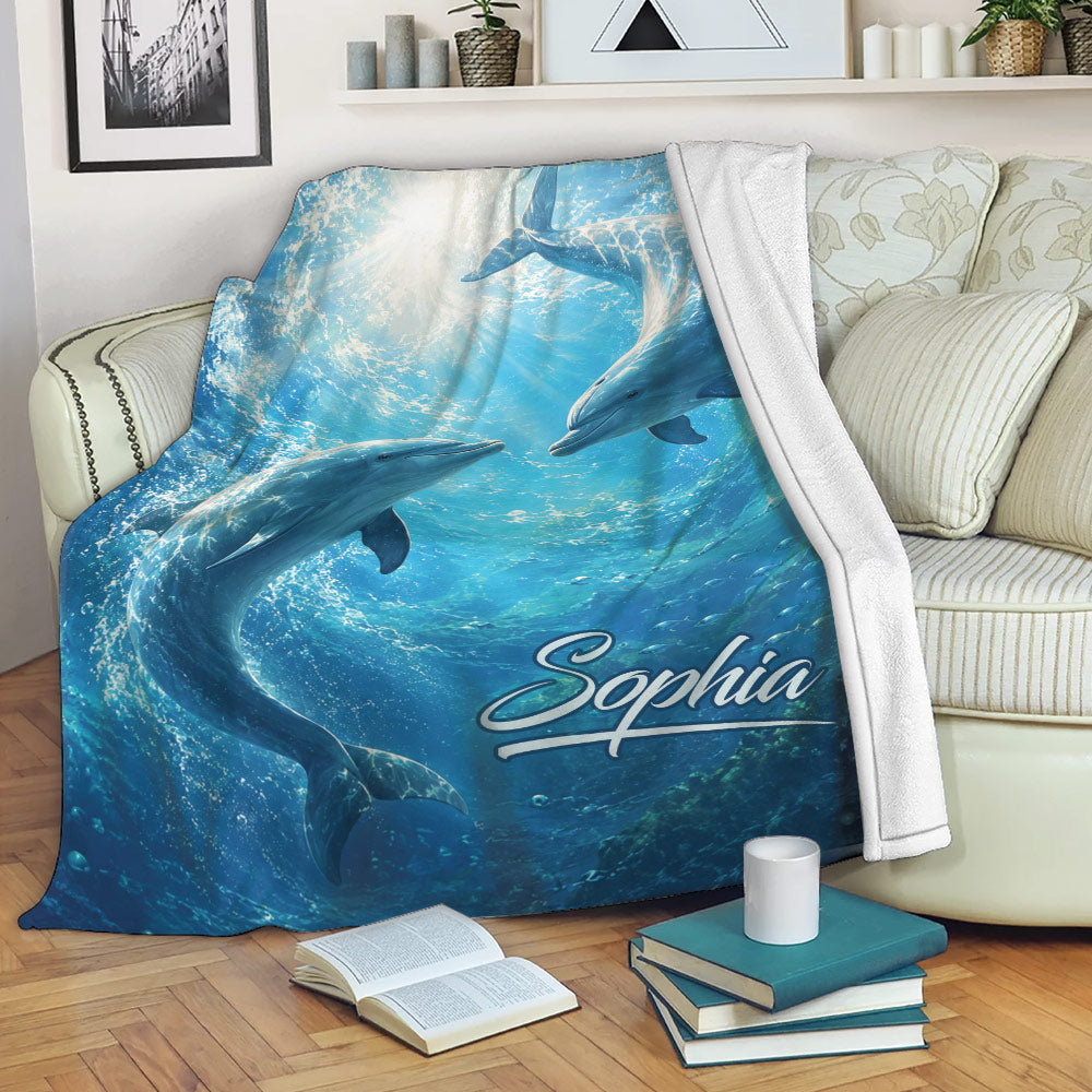 Dolphin throw blanket draped over a sofa with vivid underwater artwork and ocean colors