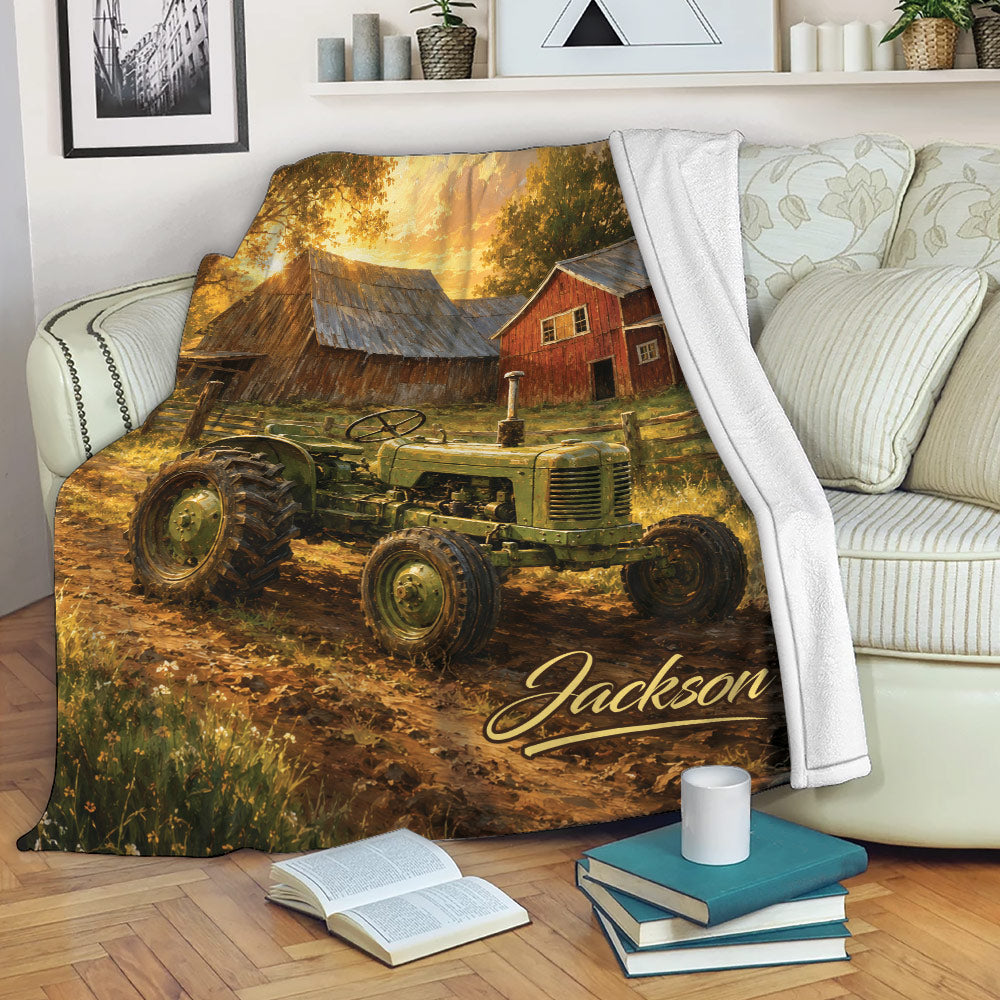 Tractor throw blanket draped over a sofa with vintage farm artwork, rustic barn scenery, and warm autumn colors
