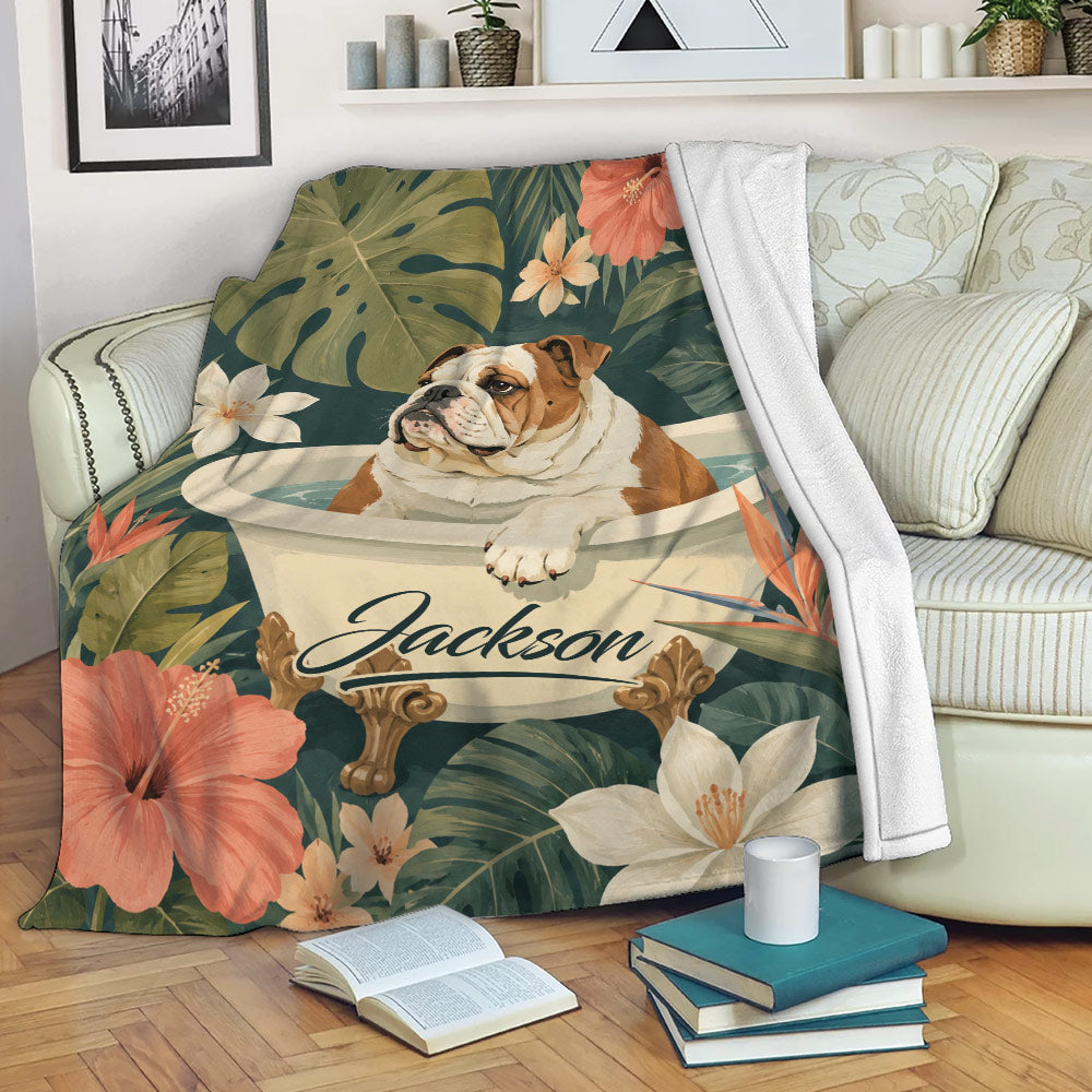 English Bulldog throw blanket displayed on a sofa with tropical flowers, botanical leaves, and a cozy reading setting