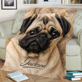 Close-up pug blanket draped across a sofa, featuring expressive eyes and detailed tan fur artwork