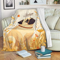 Pug blanket draped over a sofa with cozy floral artwork in cream, orange, and golden tones