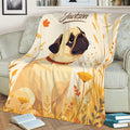 Close view of a pug throw blanket with expressive dog artwork and a warm wildflower design