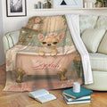 Chihuahua blanket draped over a sofa with vintage bathroom artwork and floral details