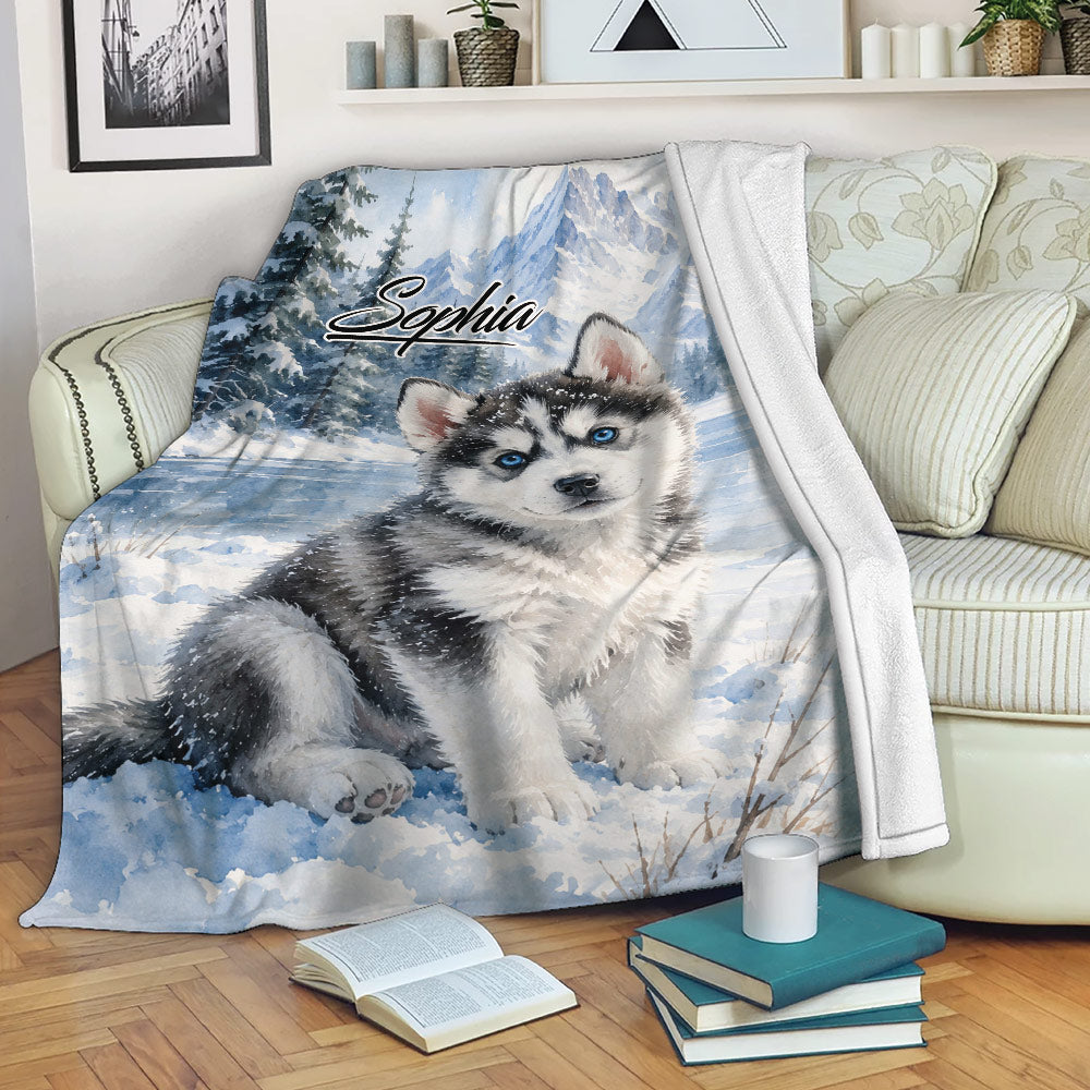 Husky throw blanket draped over a sofa with snowy watercolor dog artwork